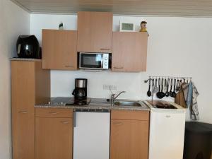 a small kitchen with a sink and a microwave at Ferienwohnung Behrens in Celle