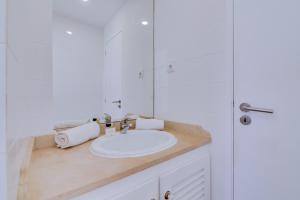 a white bathroom with a sink and a mirror at AL - Apartamento Vista Marina 1 in Vilamoura +12 photos