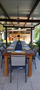un lungo tavolo in legno con sedie su un patio di Quinta do Rio Alva and Glamping Lodges a Mouronho