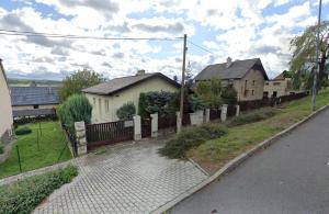 a house with a fence next to a street at Ubytování na kopečku in Beroun