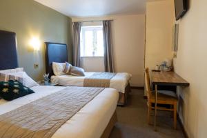 ein Hotelzimmer mit 2 Betten und einem Schreibtisch in der Unterkunft The Warehouse in Yeovil