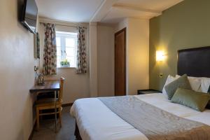 um quarto de hotel com uma cama e uma secretária em The Warehouse em Yeovil