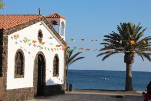 una iglesia junto a una palmera y el océano en La Lajita Barca Beach, en Lajita