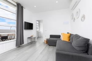 a living room with a gray couch and a large window at La Lajita Barca Beach in Lajita