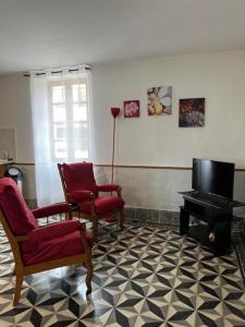 a living room with two chairs and a television at Gîtes & Chambres d'hôtes Peyrecout in Laparrouquial