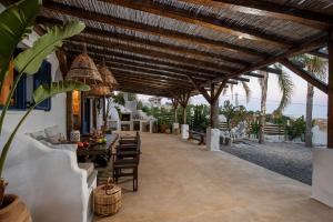 an outdoor dining area with a wooden ceiling and tables and chairs at Ninémia Sea living in Archangelos