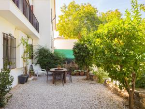 un patio con mesa y árboles en un edificio en Cubo's La Cimada Room 1 Bed&Breakfast, en Ronda
