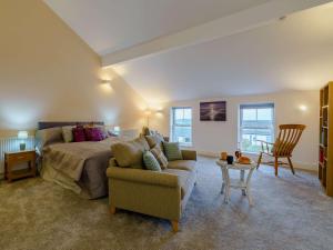 a bedroom with a bed and a couch and a table at 1 bed in Cartmel 85499 in Cark