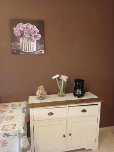 a white cabinet with flowers in vases on it at Villa Rosetta relax in Scrutto