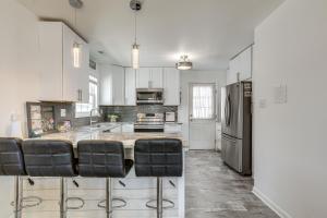 a kitchen with white cabinets and a island with bar stools at Atlantic City Home with Gas Grill Near 8 Beaches! in Atlantic City