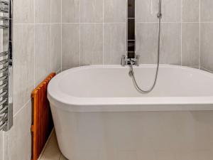 a white bath tub in a bathroom with a shower at 3 Bed in Tenby 60757 in Tenby