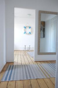 a hallway with a mirror and a rug at Char Wohnung mit 3 Schlafzimmern in Bremen