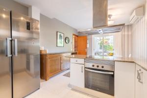 a kitchen with a stove and a refrigerator at Villa Mar - Can Bujosa in Palma de Mallorca