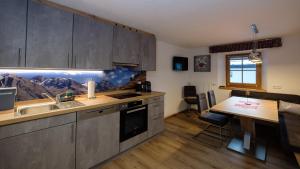 a kitchen with a sink and a table with a counter at Gasthof Hirschen in Kappl