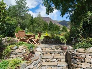 a patio with two chairs and a table in a garden at 3 Bed in Threlkeld SZ421 in Threlkeld