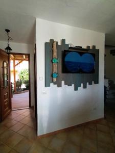 a tv on a wall in a room at Il Miraggio Tanca Piras in Nebida