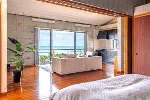 a living room with a couch and a view of the ocean at ヴィラ カエルラ in Nago