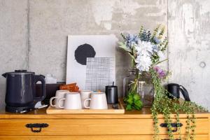 a table with cups and flowers and a picture at ヴィラ カエルラ in Nago