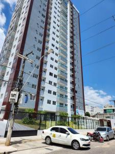 a white car parked in front of a tall building at Residencial Foz do Iguaçu. in Belém