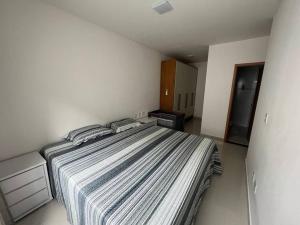 a bedroom with a large bed in a white room at Residencial Foz do Iguaçu. in Belém