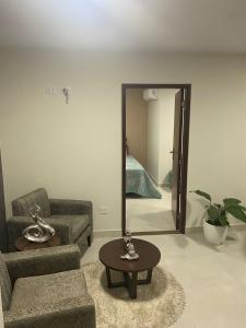 a living room with a couch and a table and a mirror at Elegante y lindo departamento in Santa Cruz de la Sierra