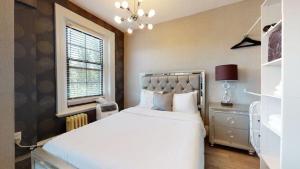 een slaapkamer met een groot wit bed en een raam bij 1-31 Excellent Location, Walk Everywhere Sleeps 3 in Boston