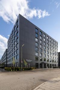 un gran edificio negro al lado de una calle en The Base Munich en Múnich