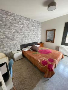 a bedroom with a large bed and a brick wall at Casa Cal Gansoleta in La Coma i la Pedra