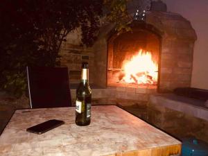 a bottle of wine sitting on a table in front of a fireplace at Celý dům + zahrada in Pardubice