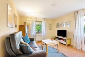 sala de estar con sofá y TV en Haus Latt, en Durbach