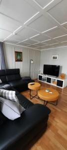 a living room with a black couch and tables at Ferienwohnung Florida in Stein