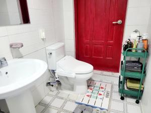 uma casa de banho com uma porta vermelha e um WC branco em Cheondongro Seonwoo stay em Jeonju