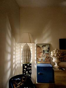 a room with a lamp and a chair and a picture at Sosò Art b&b in Positano