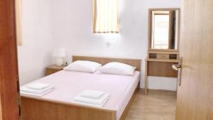 sypialnia z łóżkiem z białymi prześcieradłami i lustrem w obiekcie Cosy Apartment in Ražanac 34 m² + View w Ražancu