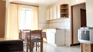 kuchnia ze stołem, krzesłami i telewizorem w obiekcie Cosy Apartment in Ražanac 34 m² + View w Ražancu