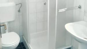 biała łazienka z toaletą i umywalką w obiekcie Cosy Apartment in Ražanac 34 m² + View w Ražancu