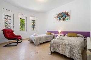 una habitación con dos camas y una silla roja en Villa Cristal, en Miami Platja 31 fotos más