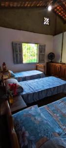 a bedroom with three beds and a window at Eco Hostel Lunar in Soure