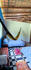 a room with two beds and a hammock on the floor at Eco Hostel Lunar - Hospedagem Rural - Entrada pelo Sitio da familia Cassiano -Tucumanduba in Soure