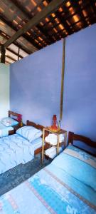 a bedroom with three beds and a table in it at Eco Hostel Lunar in Soure