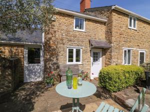 une table devant une maison en briques dans l'établissement Tiddlers Cottage, à Bridport