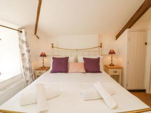 Un pat sau paturi într-o cameră la Tiddlers Cottage