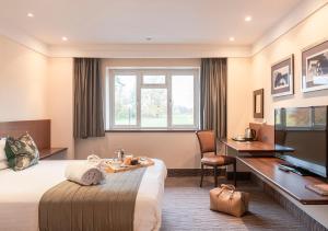 een hotelkamer met een bed en een bureau bij Thatchers Bar & Restaurant in East Horsley