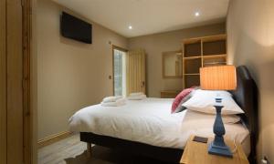 a bedroom with a bed and a table with a lamp at Abbots Reading Mews 1 in Lake Side