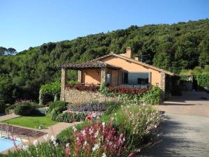 a house with a garden in front of a mountain at Villaflair - Sea View Porto Ercole in Porto Ercole