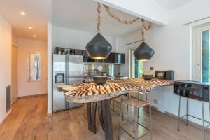 a kitchen with a table with chairs and a refrigerator at Villaflair - Villa Saturnia in Saturnia