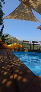 a swimming pool with two chairs next to it at Cabaña Cristal 