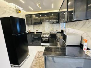 MadinatyMadinaty Hotel Apartment的厨房配有黑色橱柜和黑色冰箱。 更多14张照片