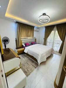 MadinatyMadinaty Hotel Apartment的一间卧室，配有一张大床和一扇大窗户。