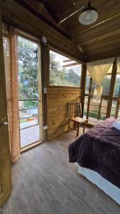 a bedroom with a bed and a large window at Cabaña Cristal 